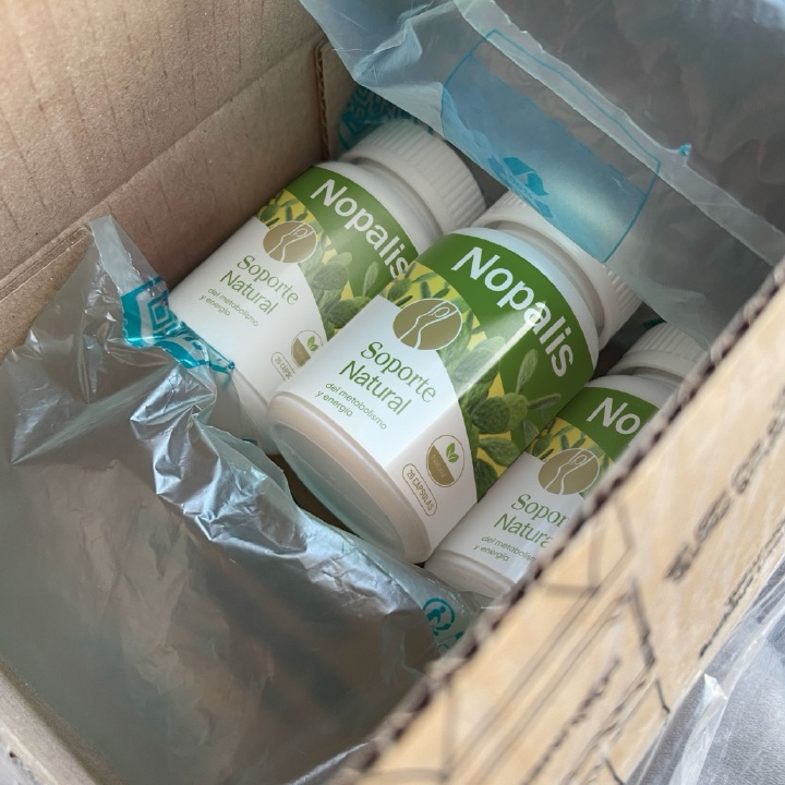 Caja de mensajería abierta con varios frascos de Nopalis dentro