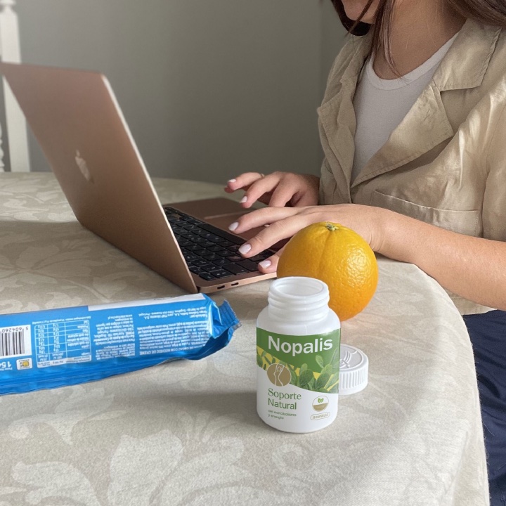 Frasco de Nopalis en un escritorio junto a una laptop y una botella de agua